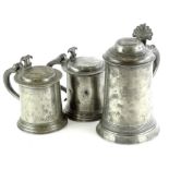 Three 19thC pewter lidded tankards, to include a straight sided example with fan shaped thumb
