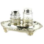 A Victorian silver inkstand, of oval form with gadrooned borders, engraved with the initials WC, the