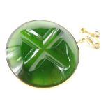 A jade brooch, the circular jade centre carved with cross type etching in a yellow metal frame,