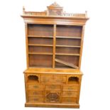 A late Victorian burr oak secretaire bookcase, the top with a breakfront cornice, carved with