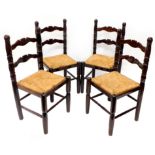 A set of four stained beech ladder back Baltic style dining chairs, each with a rush seat.