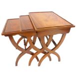 A nest of three mahogany occasional tables, each with a shallow gallery, on X shaped end supports,