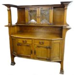 A late 19thC oak Arts and Crafts sideboard in the manner of Liberty, the raised back with two leaded