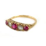 A gypsy ring, set with three rubies and two imitation diamonds, in raised scroll setting, yellow