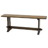 A small oak bench/coffee table, with shaped end supports, 121cm W.