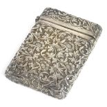 A silver coloured metal card case, with embossed and repousse decoration of foliate scrolls,