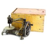 A Jones cast iron sewing machine, decorated in gilt with hour glass shaped base and wooden box