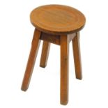 A small Arts and Crafts style stool, with a circular dished top, on chamfered legs, 30cm dia.