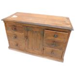 A Victorian pitch pine dresser base, the top with a moulded edge above a panel door, flanked by