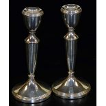 A pair of Elizabeth II silver candlesticks, of plain baluster design, on tapered circular bases,