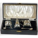 An Edward VIII three piece silver condiment set, of cauldron shaped design, raised on stylized feet,