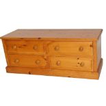 A pine low cabinet, of rectangular form, with four front drawers, on a block base, 52cm H, 130cm