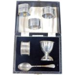 A silver christening set, comprising egg cup, spoon and napkin ring, in presentation case,