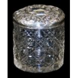 An Edwardian silver and cut glass jar and cover, the lid profusely repousse decorated with scrolls