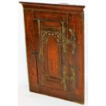 A 19thC oak hanging cupboard, of small proportion, the heavily carved door with elaborate H shaped
