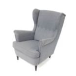 An IKEA wing armchair, upholstered in grey button back fabric, raised on ebonised turned legs.