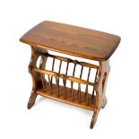 An Ercol oak Canterbury occasional table, with an oblong top, raised on trestle ends, joined by a