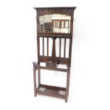 A Victorian oak hall stand, the outswept pedimented back over a bevelled glass mirror and shaped