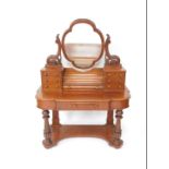 A Victorian mahogany duchess dressing table, the shaped swing frame mirror on leaf scroll