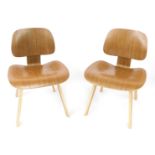 A pair of oak LCW chairs, after designs by Charles & Ray Eames, with shaped back rest and seat
