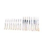 A set of eight George V silver fruit knives and forks, with mother of pearl handles, engraved