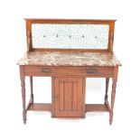 A Victorian walnut wash stand, with a foliate blue tile splash back, veined red marble top, over a