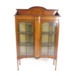 An Edwardian mahogany and inlaid display cabinet, with a galleried top over two glazed doors