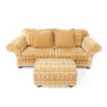 A two seater sofa by Mark Webster, with tapestry upholstery and having shaped back, scroll arms
