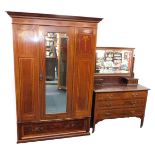 An Edwardian mahogany and satinwood cross banded double wardrobe, the outswept pediment over a