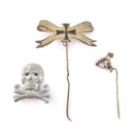 A Third Reich NSBO Trade Union lapel pin, an Iron Cross and bow tie pin, and a Totenkopf badge. (3)