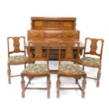 A 1930's oak dining suite, comprising a bow front panel back sideboard, with three floral carved