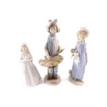 A Lladro porcelain figure of a girl, modelled standing holding a rag doll, 28cm H, together with a