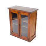 A Victorian mahogany display cabinet, the outswept pediment over two glazed doors enclosing two