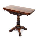 A Regency mahogany fold over tea table, with floral and foliate carved frieze, raised on a turned