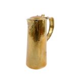 An Arts & Crafts brass jug, of tapering form with a hinged lid, hammered decoration and copper
