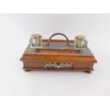 A Victorian oak and brass mounted desk stand, with a pair of facetted cut glass inkwells with