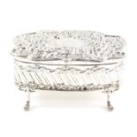 An Edward VII silver jewellery casket, the hinged lid embossed with rococo scroll, flowers and