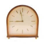A 1950's light oak cased Smiths mantel clock, of domed form, the cream dial bearing gilt batons,