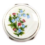 A silver and guilloche enamel compact, the lid with a sunburst design over painted with thistles and