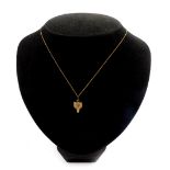 A 9ct gold pendant modelled as a fox's head, with gem set eyes, on a yellow metal neck chain,