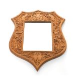 A Victorian oak shield shape wall mirror, rectangular set with bevelled glass, carved with beast's