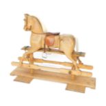 A pine rocking horse, with leather saddle, stirrups, etc, 113cm H, 154cm W.