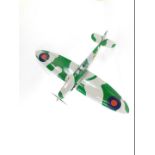 A kit built model of a Spitfire, camouflage painted, with military decals, 110cm L, 145cm W.