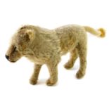 An early 20thC golden plush lion, 23cm H x 48cm L.