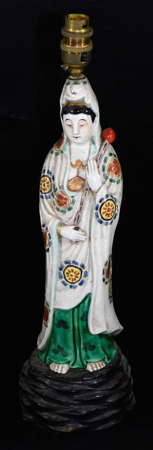 A 19thC Japanese Kutani figure of the Goddess Kannon, carrying a lotus bud, dressed in white robe,