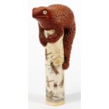 A Japanese bone column with applied toad figural surmount, the main body decorated with insects,