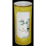 A Chinese porcelain cylindrical spill vase decorated with panels of tree peony, on a yellow ground