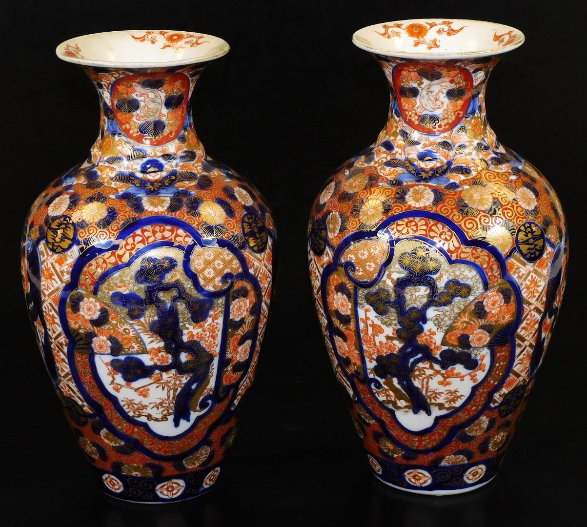 A pair of Meiji period Japanese Imari vases, each of baluster form, profusely decorated with panels,