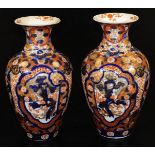 A pair of Meiji period Japanese Imari vases, each of baluster form, profusely decorated with panels,