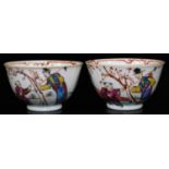 A near matching pair of Chinese Qing dynasty porcelain tea bowls, each decorated in green, yellow,